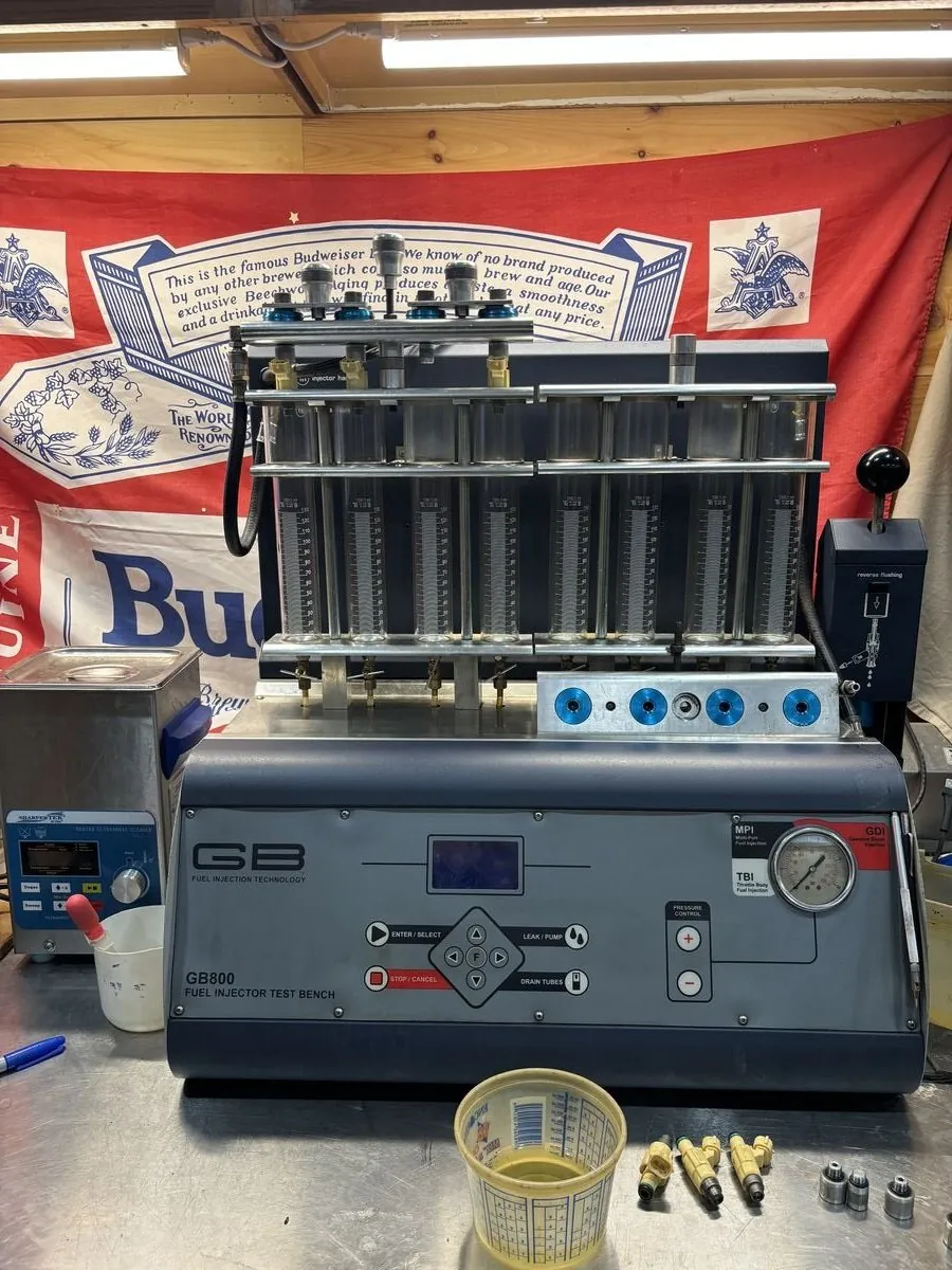 Fuel injectors on the flow bench being tested before and after cleaning