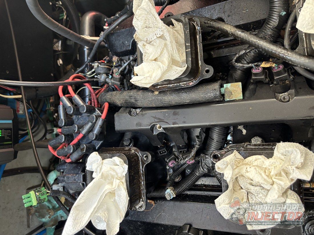 Pulling fuel injectors on a Mercruiser 7.4 marine engine in the field
