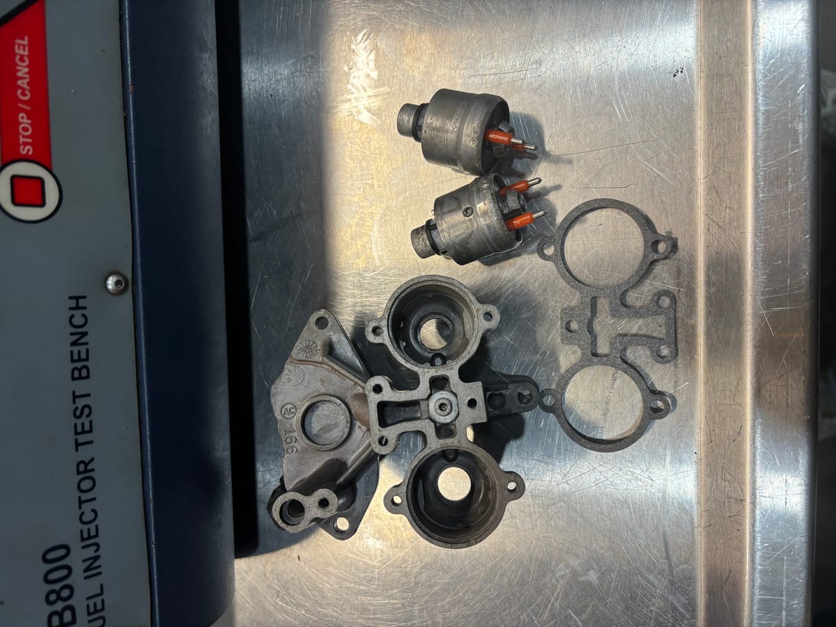 Disassembled TBI unit with injectors and throttle body